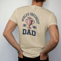 Man wearing a Sandstone tee, seen from the back: a trophy cup topped with a sneaker and a ribbon under World's Freshest and a giant Dad, as a two-ink streetwear graphic in navy and orange.