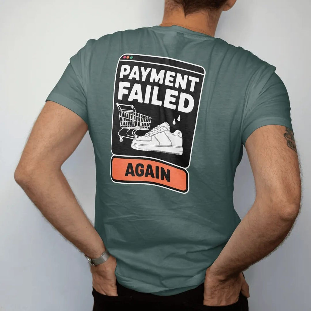 Man wearing a Blue Spruce tee, seen from the back: a retro error pop-up with a broken cart and sweating sneaker, titled Payment Failed with an Again button, as a two-ink streetwear graphic in off-white and orange.