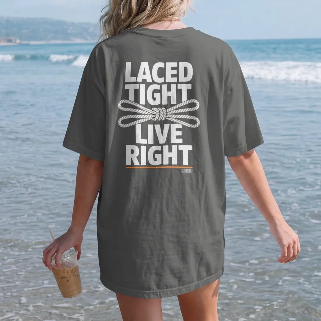 Woman on the beach in a Pepper tee, back view: a close-up of sneaker eyelets with a tidy bow knot framed by Laced Tight and Live Right, as a two-ink streetwear graphic in off-white and orange.