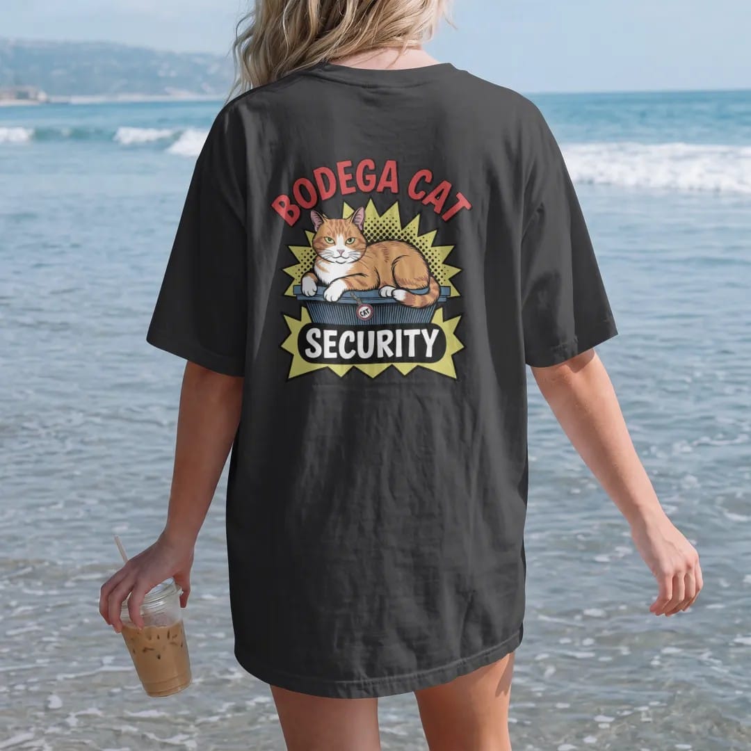 Woman on the beach in a Black tee, back view: an orange tabby lounging on a chip rack wearing a security badge, under Bodega Cat and above a Security ribbon, in halftone comic-pop red, yellow and cream.
