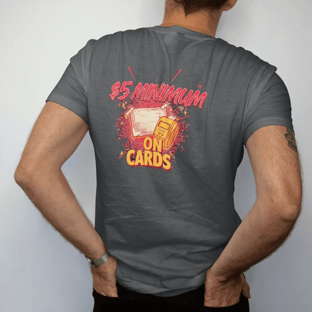 Man wearing a Graphite tee, seen from the back: a taped handwritten sign on a register beside a card reader and gum reading $5 Minimum On Cards, in halftone comic-pop red, yellow and cream.