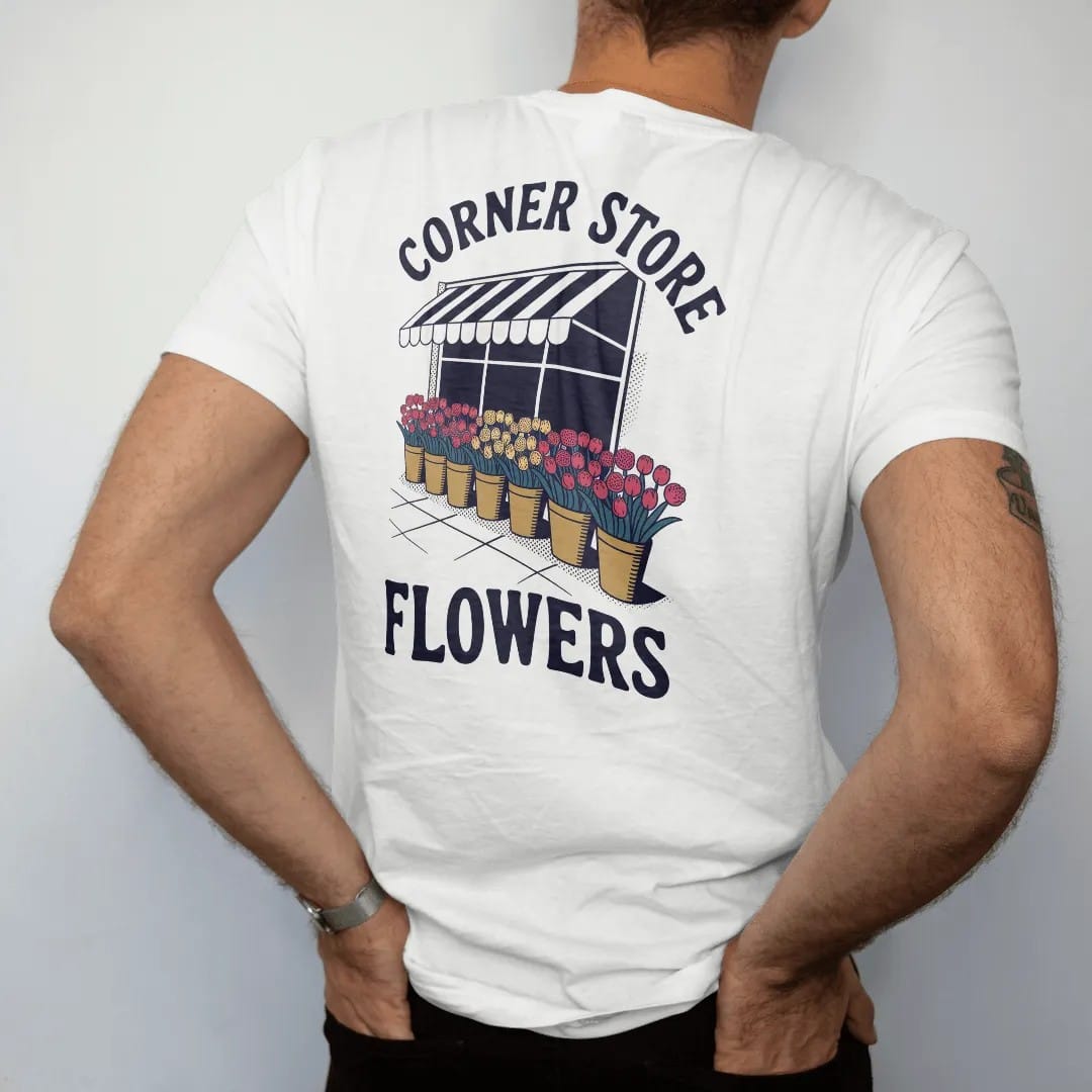 Man wearing a White tee, seen from the back: buckets of tulips, roses and carnations under a striped awning with Corner Store arched above and Flowers below, in halftone comic-pop red, mustard and navy.
