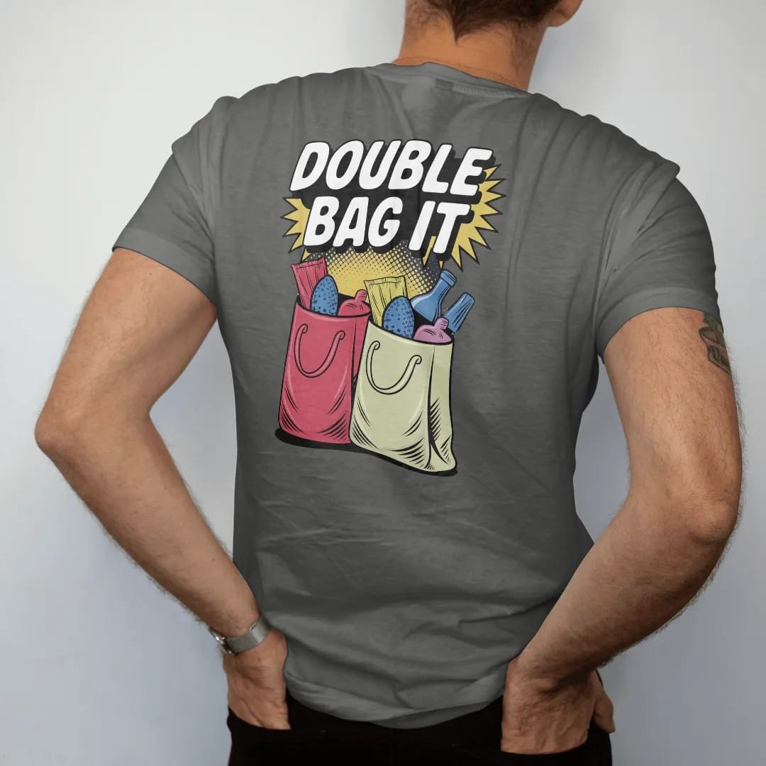Man wearing a Pepper tee, seen from the back: two plastic bags nested and stuffed with groceries and a bottle peeking out, under Double Bag It, in halftone comic-pop red, yellow and cream.