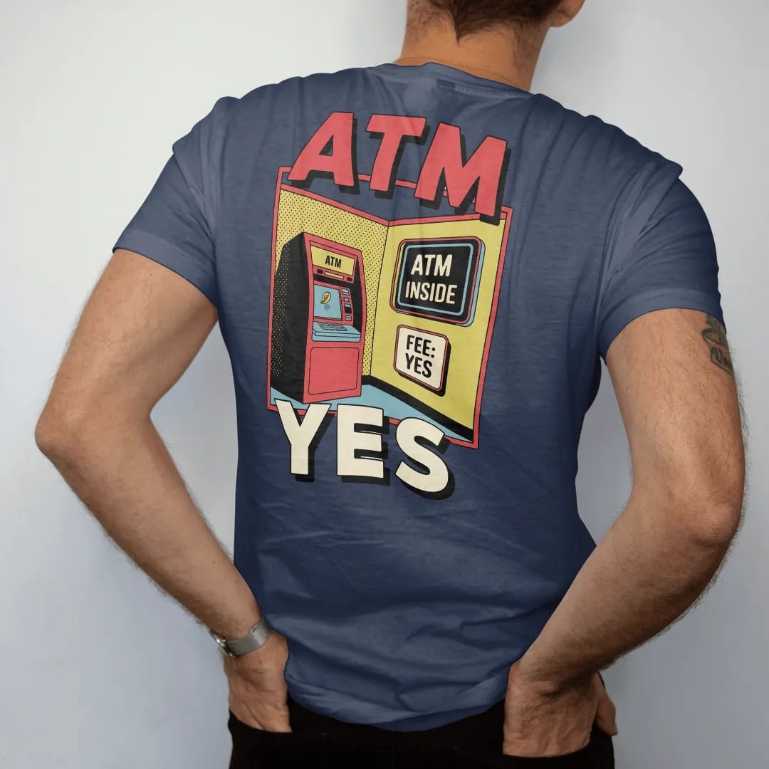 Man wearing a Navy tee, seen from the back: a clunky ATM with a glowing screen and a flying coin under a neon ATM Inside sign and a Fee: Yes placard, in halftone comic-pop red, yellow and cream.