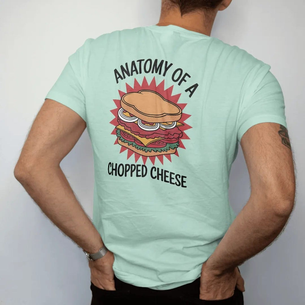 Man wearing a Chalky Mint tee, seen from the back: an exploded chopped cheese sandwich with layers separated by leader lines, under Anatomy Of A and Chopped Cheese, in halftone comic-pop red, mustard and navy.