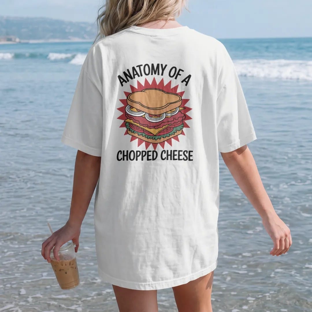 Woman on the beach in a White tee, back view: an exploded chopped cheese sandwich with layers separated by leader lines, under Anatomy Of A and Chopped Cheese, in halftone comic-pop red, mustard and navy.