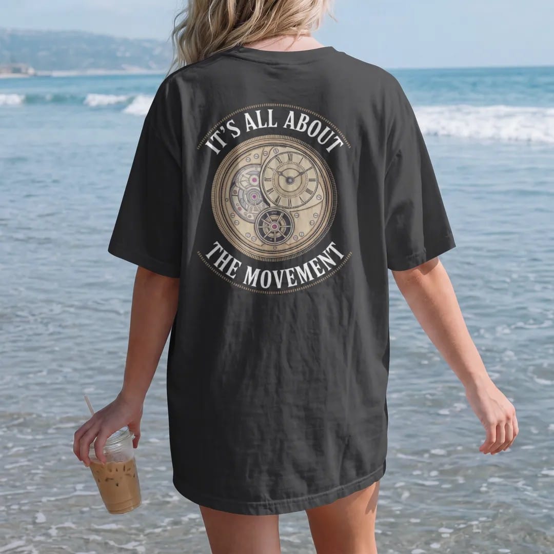 Woman on the beach in a Black tee, back view: a watch caseback revealing a mechanical movement with bridges, jewels and a rotor, under It's All About and The Movement, as a fine engraving in antique gold and cream.