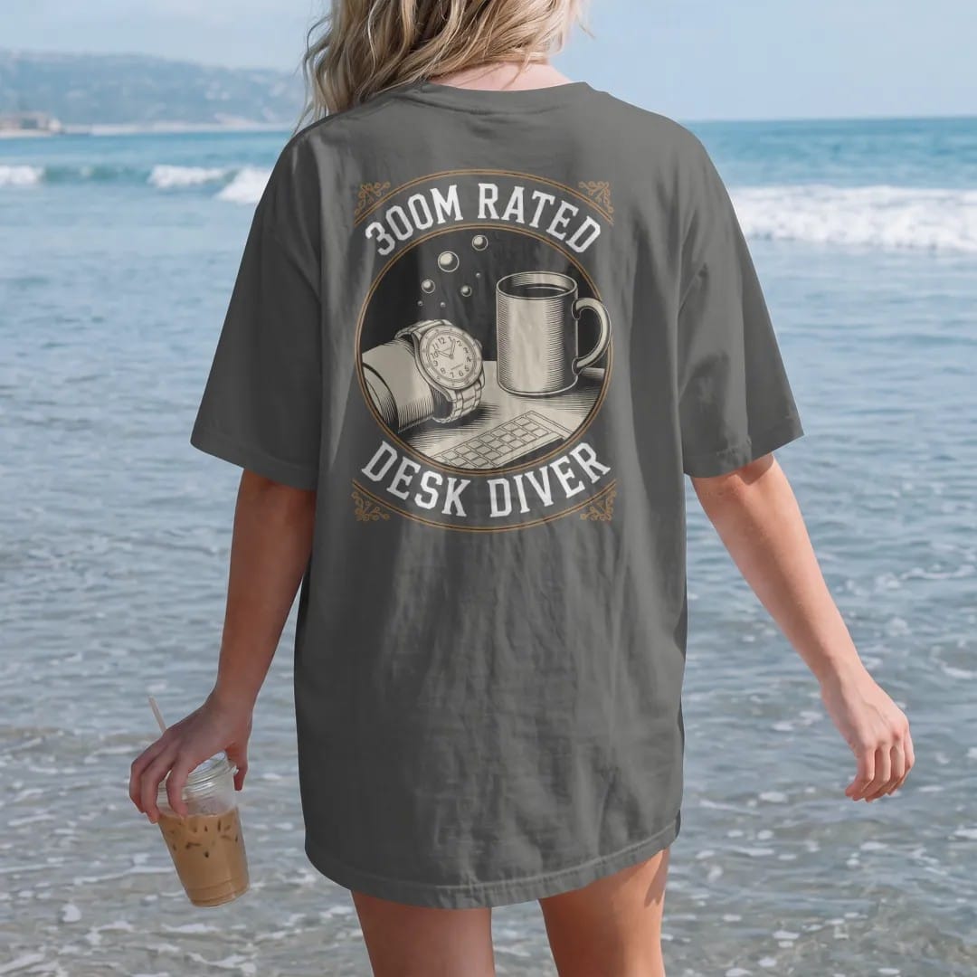 Woman on the beach in a Pepper tee, back view: a dive watch on a wrist resting on a keyboard beside a mug with floating bubbles, under 300M Rated and Desk Diver, as a fine engraving in antique gold and cream.