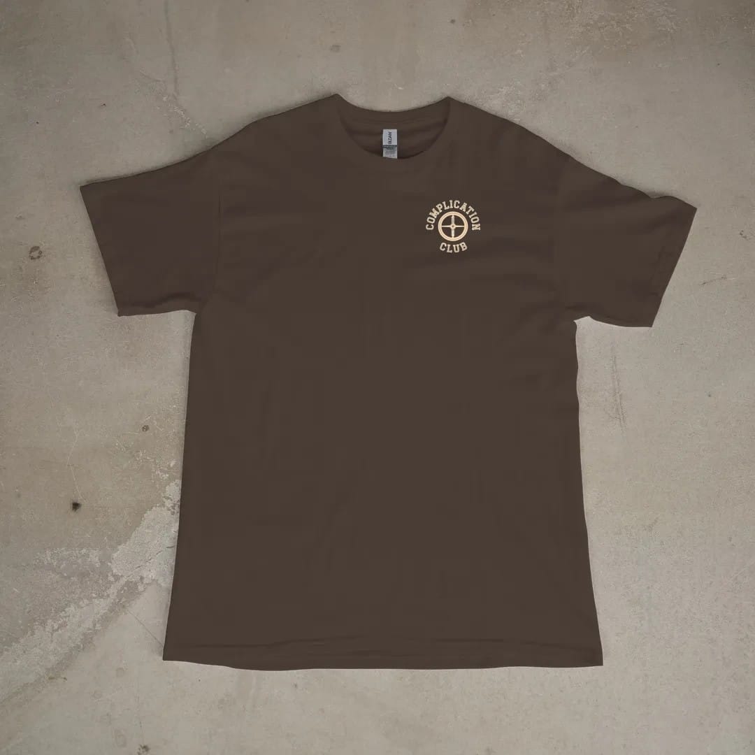 Front of a Espresso tee laid flat, with the small Complication Club logo on the left chest.