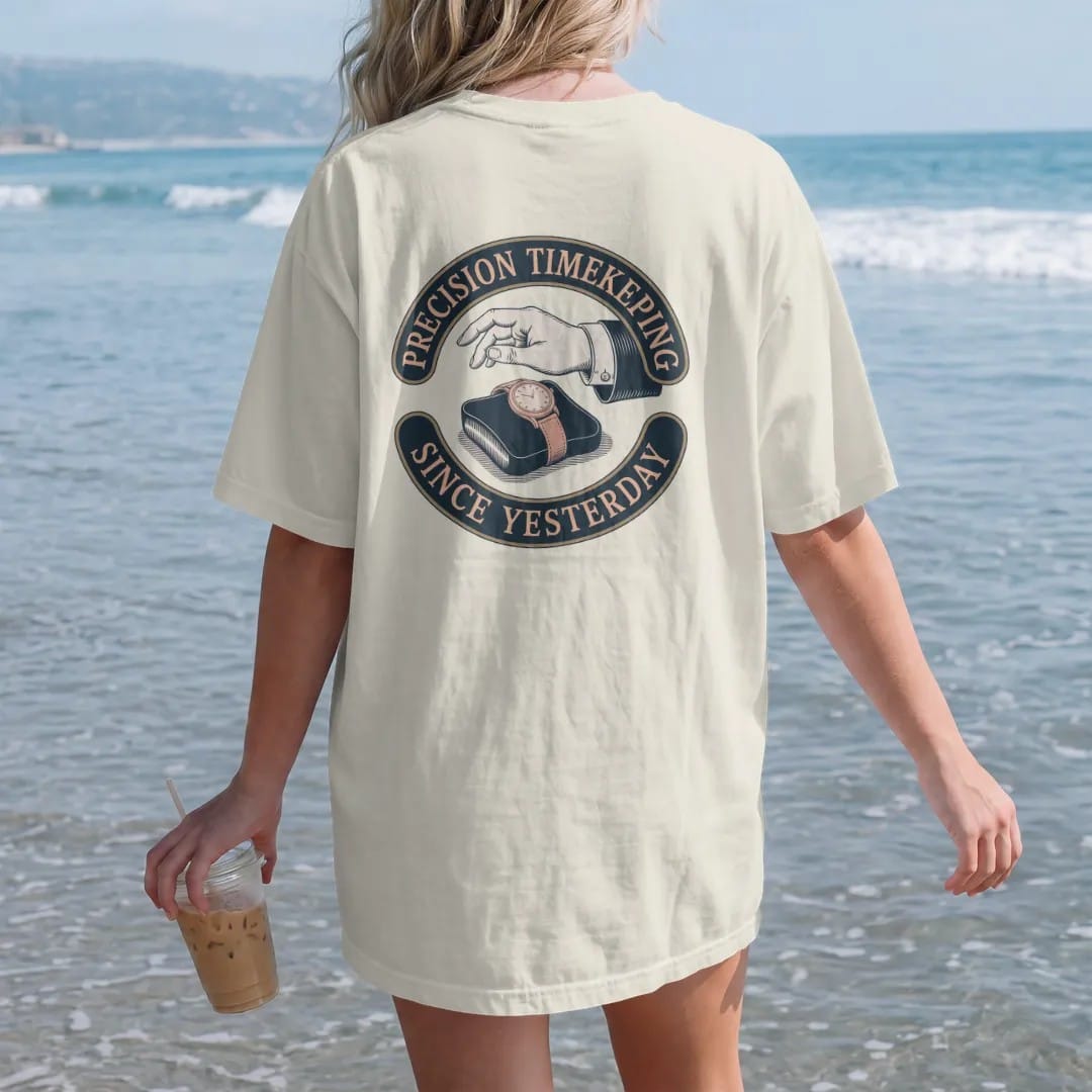 Woman on the beach in a Ivory tee, back view: a vintage ad of a hand presenting a watch on a velvet cushion with sparkles, under Precision Timekeeping and a Since Yesterday script, as a fine engraving in navy and antique brass.