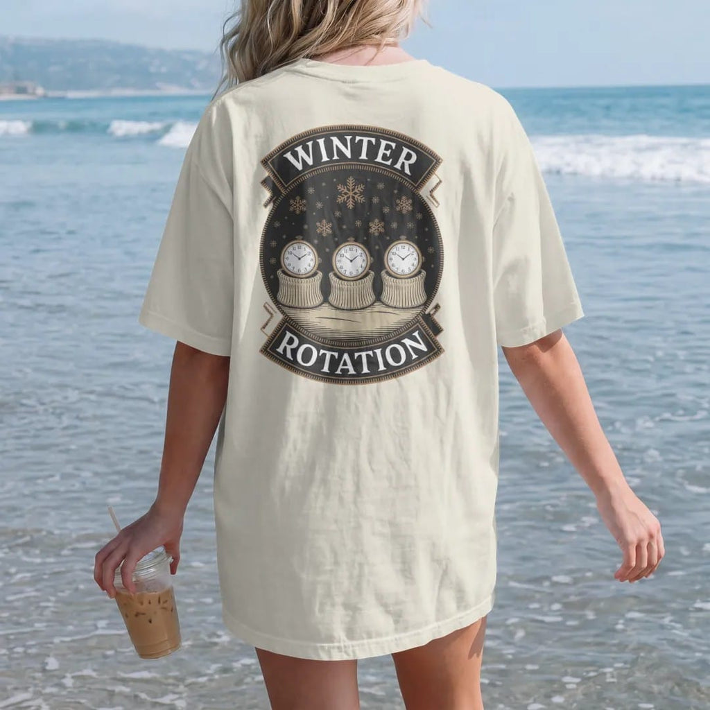 Woman on the beach in a Ivory tee, back view: three watches peeking from sweater cuffs in a row with falling snowflakes, under Winter and Rotation, as a fine engraving in antique gold and cream.