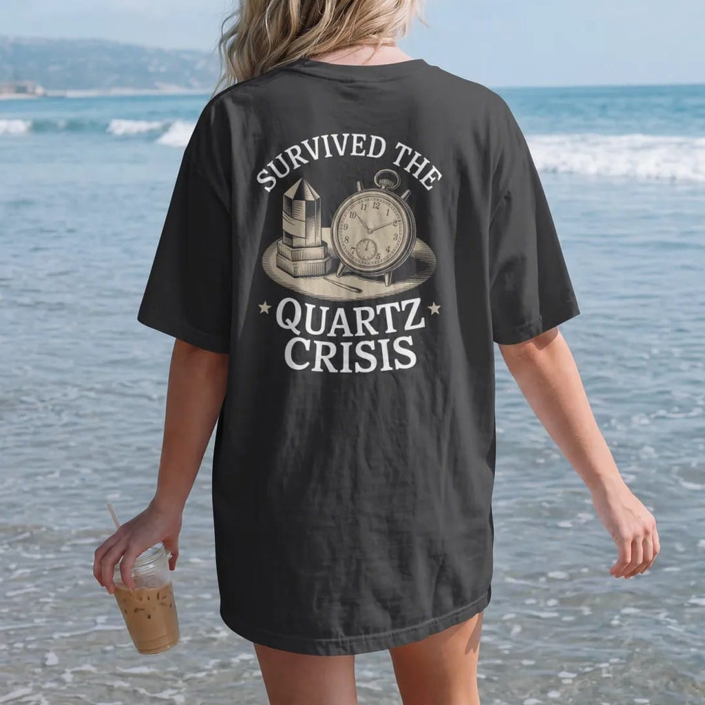 Woman on the beach in a Black tee, back view: a proud mechanical watch with a tiny bandage beside a crumbling quartz crystal, under Survived The and Quartz Crisis, as a fine engraving in antique gold and cream.