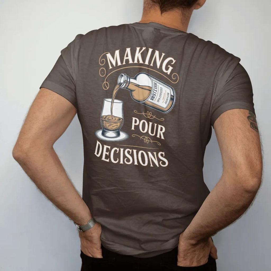 Man wearing a Espresso tee, seen from the back: an engraved bottle pouring into a glencairn glass, with "MAKING" and "POUR DECISIONS" in flowing copperplate script and bold Didone capitals, printed as a fine engraving in antique gold and warm cream.