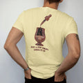 Man wearing a Butter tee, seen from the back: a glass dropper releasing drops into a glencairn glass, with "JUST A FEW DROPS" and "OPENS IT UP", printed as a fine engraving in oxblood, charred oak brown and antique gold.