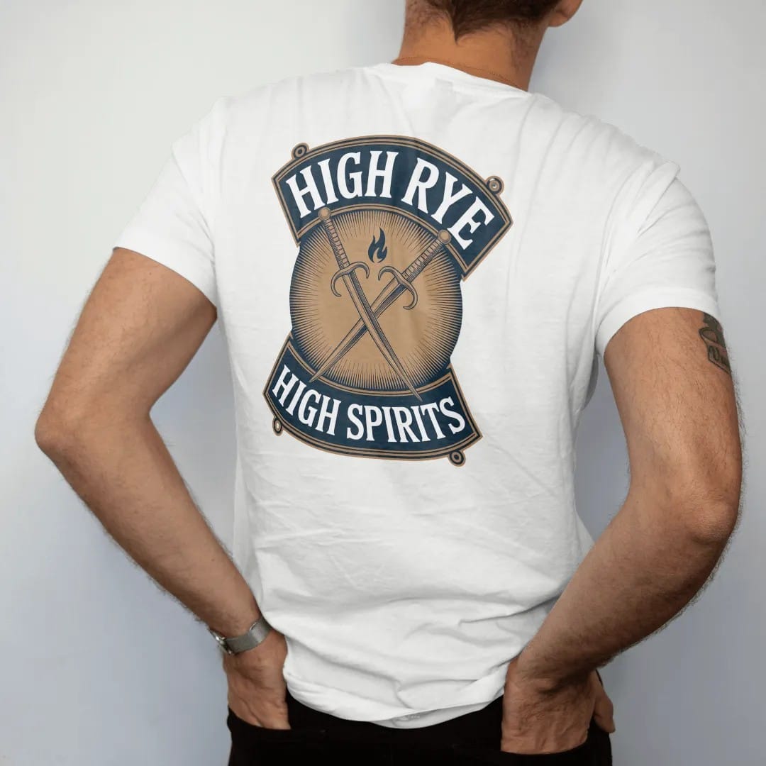 Man wearing a White tee, seen from the back: crossed rye stalks behind a small flame on a shield, with "HIGH RYE" and "HIGH SPIRITS" in condensed Victorian display capitals, printed as a fine engraving in antique gold and warm cream.