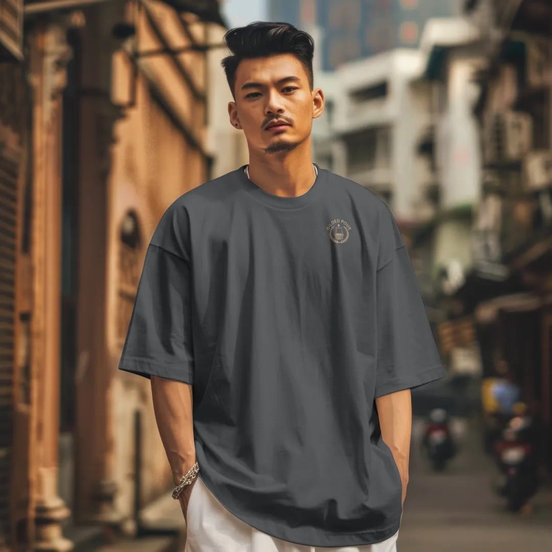 Man in a Graphite tee on a city street, with the small Gilded Pour logo on the left chest.