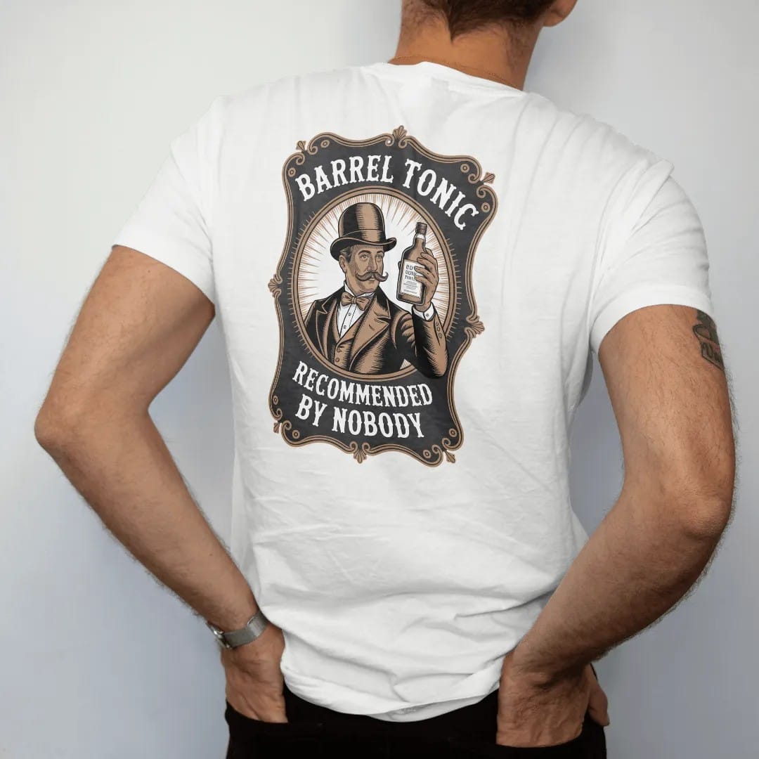 Man wearing a White tee, seen from the back: a mustached gentleman in a bowler hat holding up a whiskey bottle, with "BARREL TONIC" and "RECOMMENDED BY NOBODY", printed as a fine engraving in antique gold and warm cream.