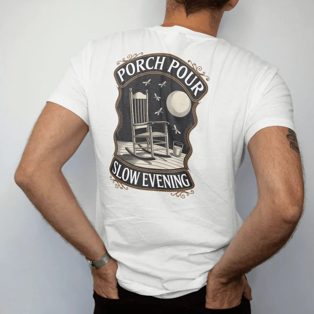 Man wearing a White tee, seen from the back: a rocking chair on a porch with a glass on the armrest under a low moon, with "PORCH POUR" and "SLOW EVENING" in warm Victorian serif capitals, printed as a fine engraving in antique gold and warm cream.