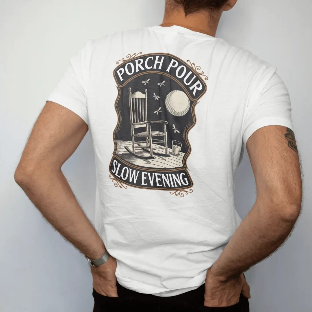 Man wearing a White tee, seen from the back: a rocking chair on a porch with a glass on the armrest under a low moon, with "PORCH POUR" and "SLOW EVENING" in warm Victorian serif capitals, printed as a fine engraving in antique gold and warm cream.