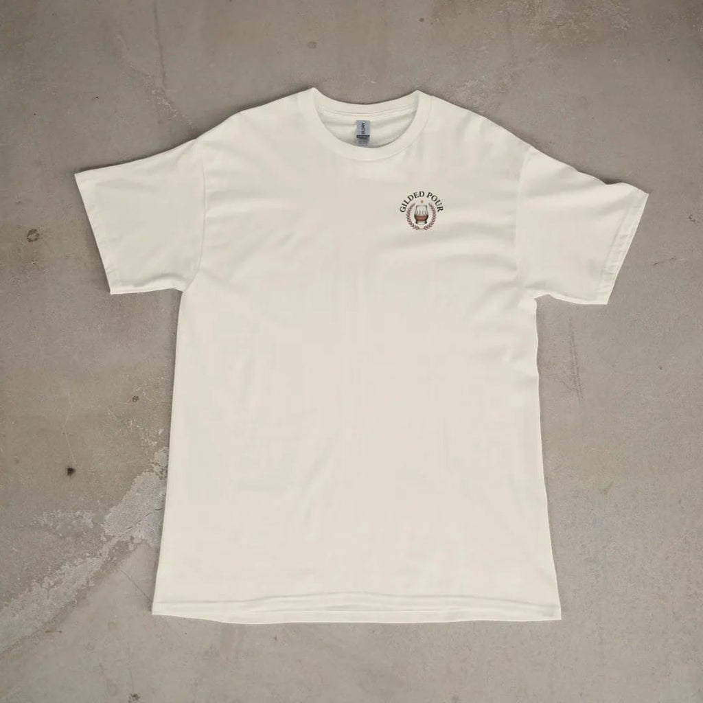 Front of a Ivory tee laid flat, with the small Gilded Pour logo on the left chest.