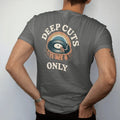 Man wearing a Pepper tee, seen from the back: a record cross-section drawn like rock layers with a tiny miner, with "DEEP CUTS" and "ONLY" in chunky 70s lettering and small 70s caps, printed in faded, cracked cream, mustard, burnt orange and faded…