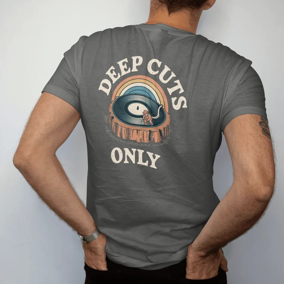 Man wearing a Pepper tee, seen from the back: a record cross-section drawn like rock layers with a tiny miner, with "DEEP CUTS" and "ONLY" in chunky 70s lettering and small 70s caps, printed in faded, cracked cream, mustard, burnt orange and faded…