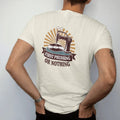 Man wearing a Ivory tee, seen from the back: a vintage record press stamping a fresh disc, with "FIRST PRESSING" and "OR NOTHING" in chunky 70s lettering and small 70s caps, printed in faded, cracked brown, burnt orange, faded teal and mustard over…