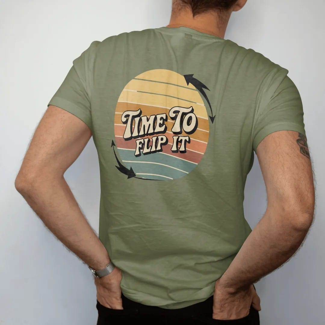 Man wearing a Moss tee, seen from the back: a record flipping mid-air with motion arrows, with "TIME TO" and "FLIP IT" in chunky 70s lettering and small 70s caps, printed in faded, cracked cream, mustard, burnt orange and faded teal over faded…