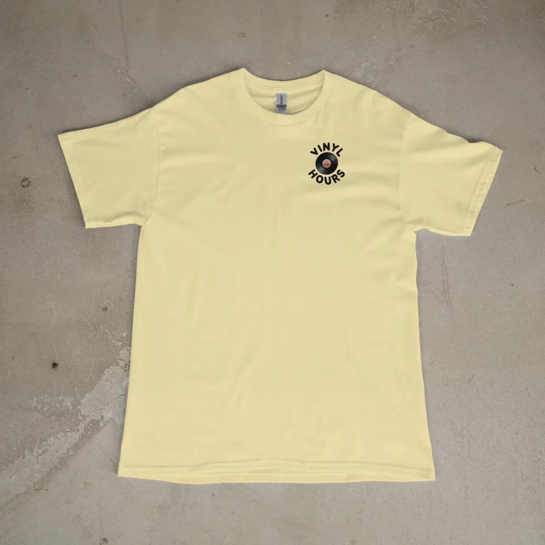 Front of a Butter tee laid flat, with the small Vinyl Hours logo on the left chest.