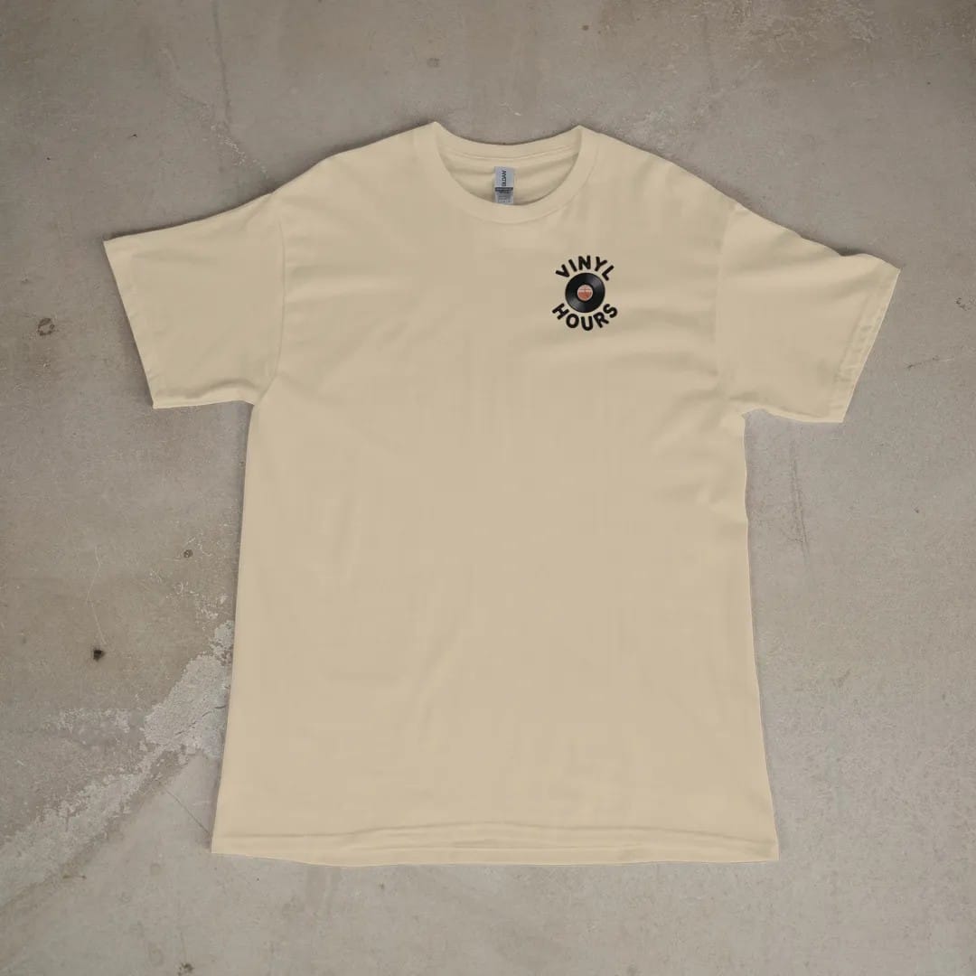 Front of a Sandstone tee laid flat, with the small Vinyl Hours logo on the left chest.
