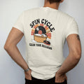 Man wearing a Ivory tee, seen from the back: a record in a bubble bath beside a cleaning-machine dial, with "SPIN CYCLE" and "CLEAN YOUR RECORDS" in chunky 70s lettering and small 70s caps, printed in faded, cracked cream, mustard, burnt orange and…