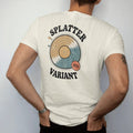 Man wearing a Ivory tee, seen from the back: a paint-splatter colored record with a limited-edition sticker, with "SPLATTER" and "VARIANT" in chunky 70s lettering and small 70s caps, printed in faded, cracked cream, mustard, burnt orange and faded…