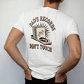 Man wearing a White tee, seen from the back: a record shelf with a taped warning sign and a padlocked turntable, with "DAD'S RECORDS" and "DON'T TOUCH" in chunky 70s lettering and small 70s caps, printed in faded, cracked cream, mustard, burnt…