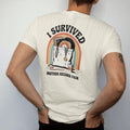 Man wearing a Ivory tee, seen from the back: an overstuffed tote bag of records with a medal ribbon, with "I SURVIVED" and "ANOTHER RECORD FAIR" in chunky 70s lettering and small 70s caps, printed in faded, cracked cream, mustard, burnt orange and…