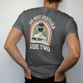 Man wearing a Graphite tee, seen from the back: a person in over-ear headphones with a cord leading to a turntable, with "DO NOT DISTURB" and "SIDE TWO" in chunky 70s lettering and small 70s caps, printed in faded, cracked cream, mustard, burnt…