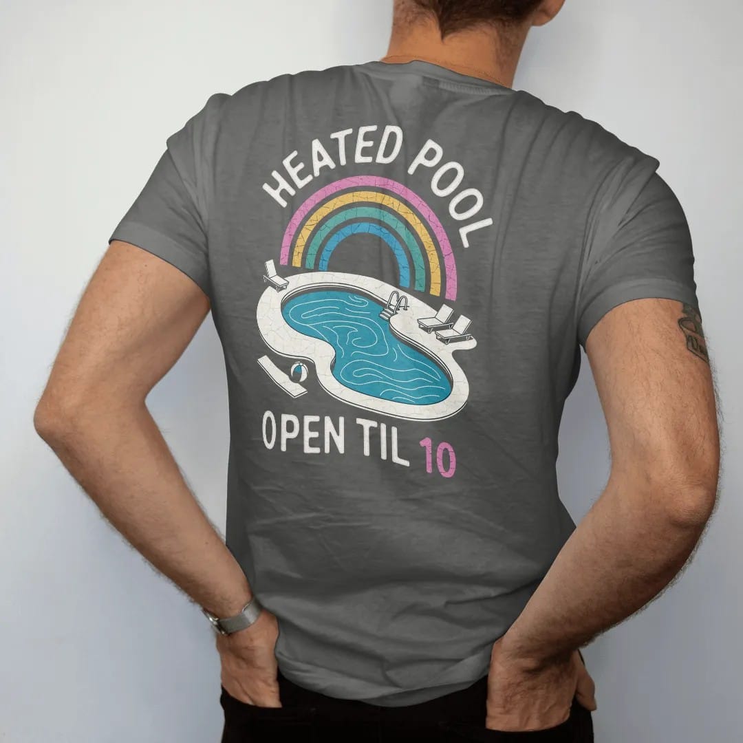 Man wearing a Pepper tee, seen from the back: a kidney-shaped motel pool from above with loungers and a diving board, with "HEATED POOL" and "OPEN TIL 10" in neon-tube script and small 70s caps, printed in faded, cracked cream, mustard and…
