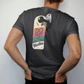 Man wearing a Black tee, seen from the back: a retro door hanger with a sleeping moon on a motel doorknob, with "DO NOT DISTURB" and "ON VACATION" in chunky 70s lettering and brush script, printed in faded, cracked cream, mustard and turquoise with…