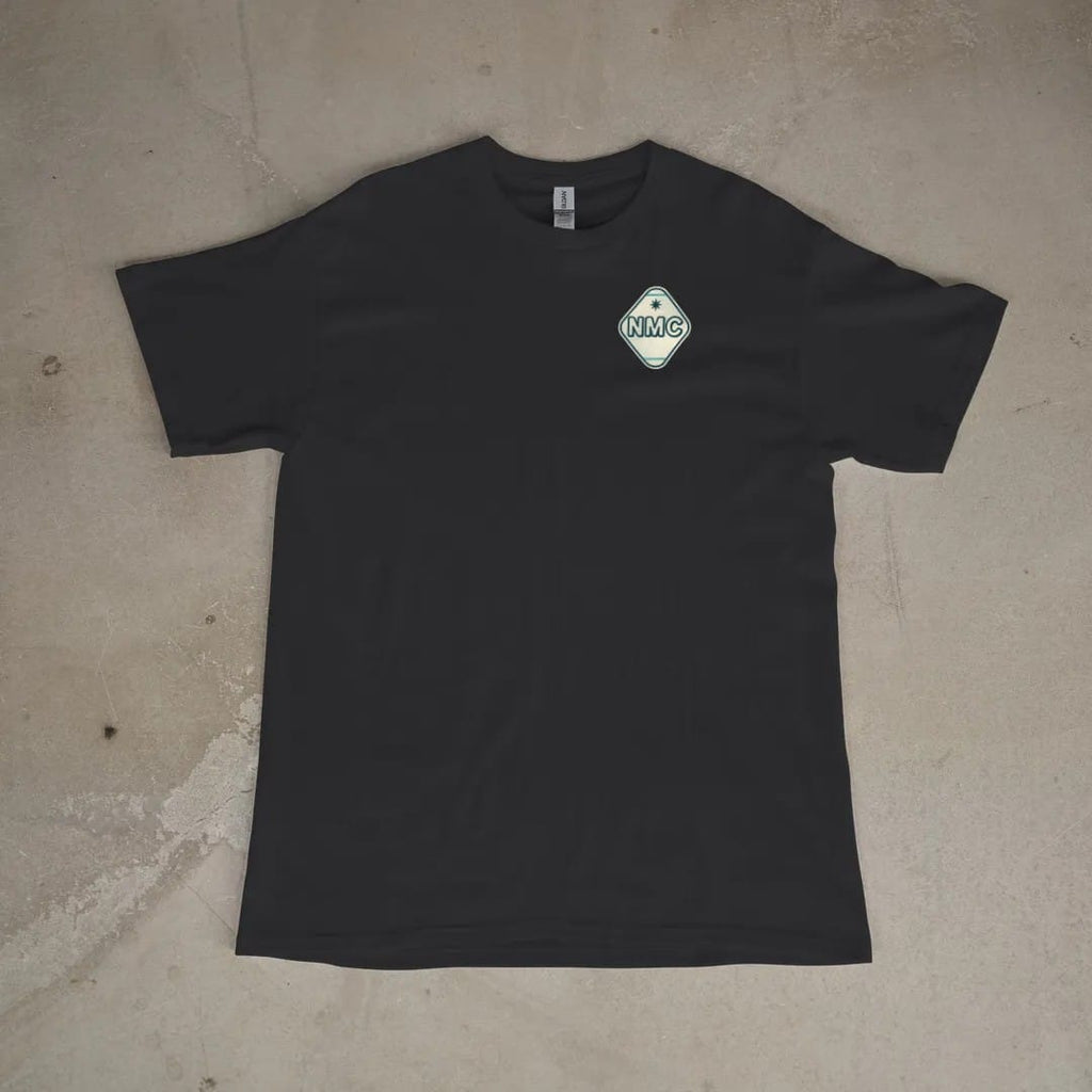Front of a Black tee laid flat, with the small Neon Motor Court logo on the left chest.