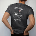 Man wearing a Black tee, seen from the back: minimal single-line drawing of a simple sofa outline with a laptop and a paper plane floating up from it, with "SENT FROM / MY COUCH" in small spaced-out caps, printed in bone white with a low-battery…