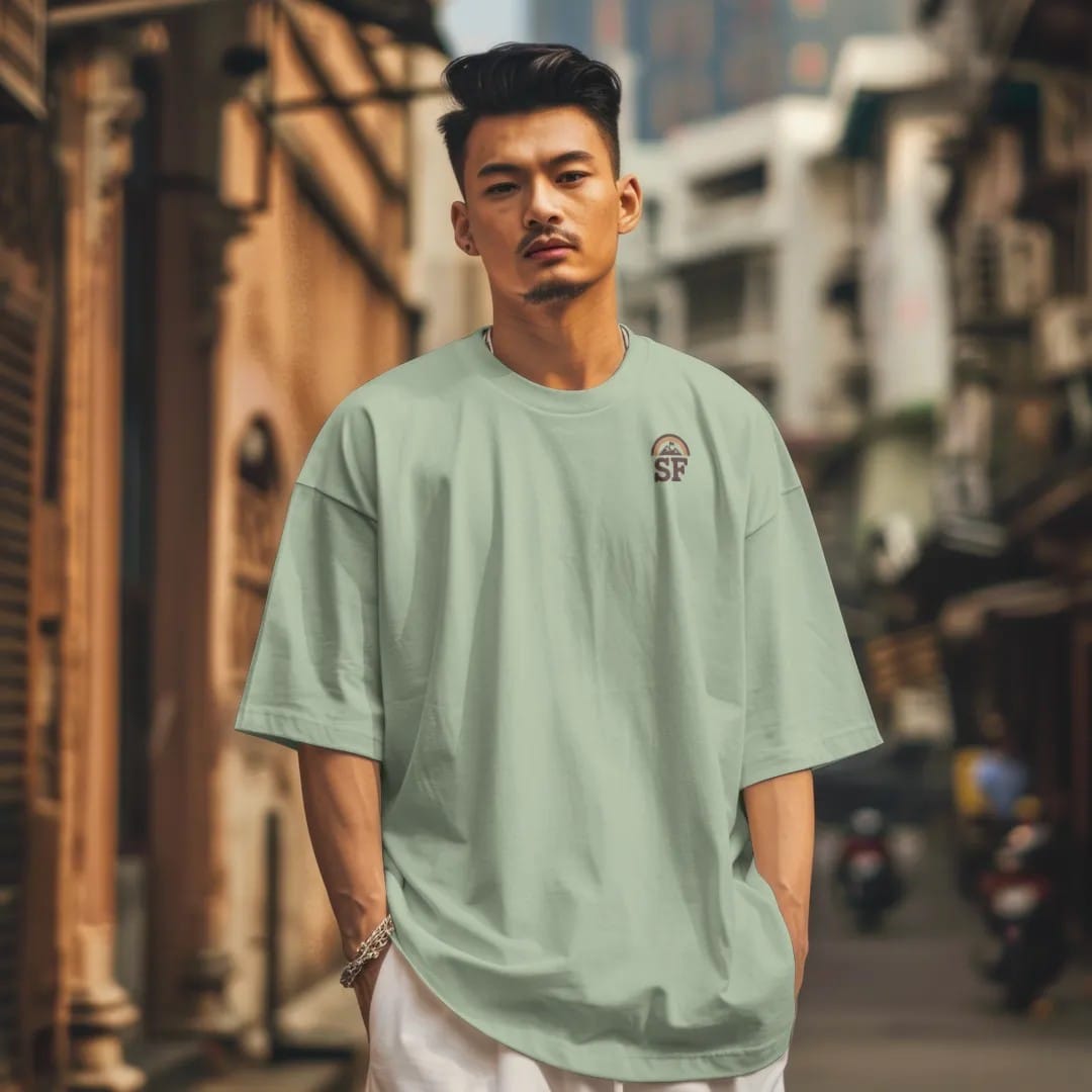 Man in a Light Green tee on a city street, with the small Summit Fever logo on the left chest.