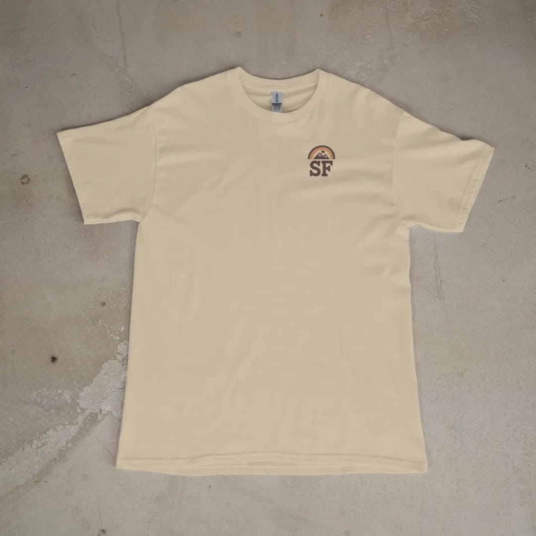 Front of a Sandstone tee laid flat, with the small Summit Fever logo on the left chest.