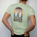 Man wearing a Light Green tee, seen from the back: a mountain stream flowing into a squeeze filter pouch and a water bottle, field-guide layout, faded 70s souvenir style, lettered "TREAT YOUR WATER" in chunky rounded 70s serif letters with a drop…