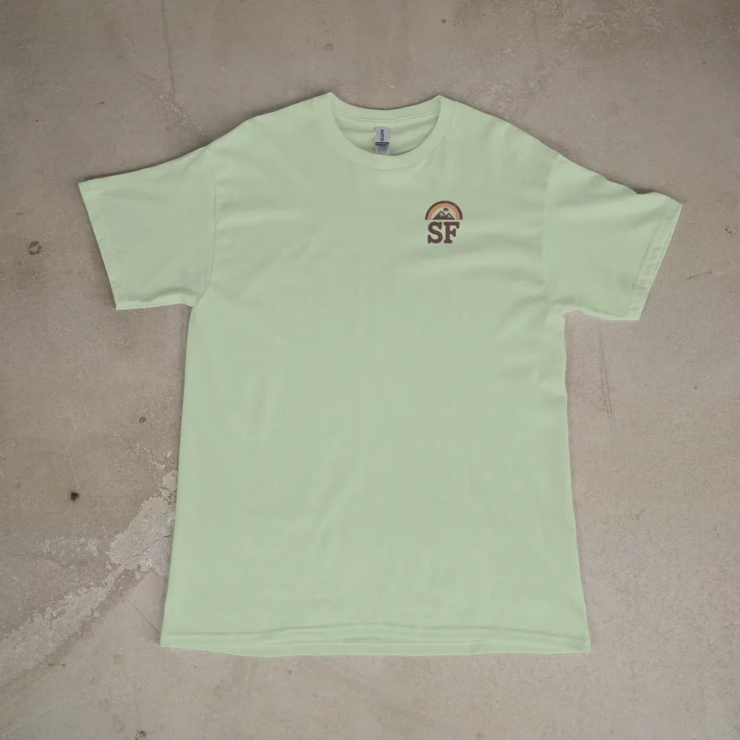 Front of a Light Green tee laid flat, with the small Summit Fever logo on the left chest.