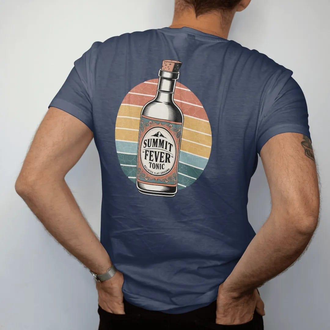 Man wearing a Navy tee, seen from the back: an antique tonic bottle with a mountain on the label, ornate scrolls and tiny banners, faded 70s souvenir style, lettered "SUMMIT FEVER TONIC / RELIEVES FLAT GROUND" in chunky rounded 70s serif letters…