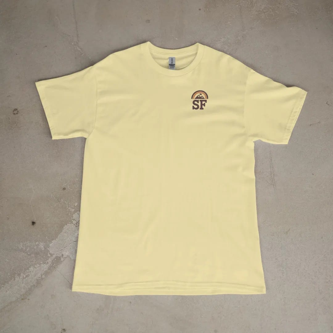 Front of a Butter tee laid flat, with the small Summit Fever logo on the left chest.