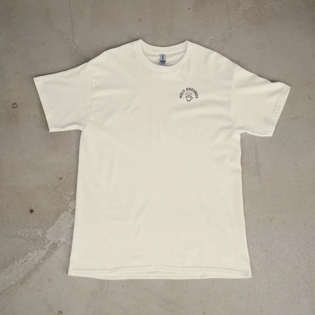 Front of a Ivory tee laid flat, with the small Holy Grounds logo on the left chest.