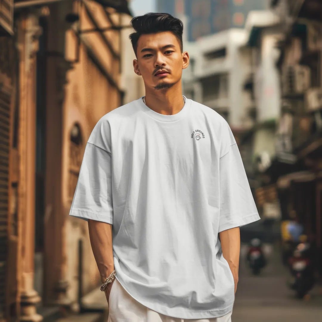 Man in a White tee on a city street, with the small Holy Grounds logo on the left chest.