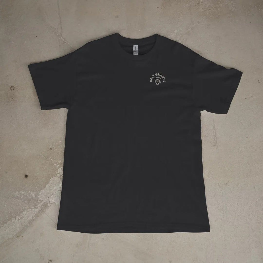 Front of a Black tee laid flat, with the small Holy Grounds logo on the left chest.