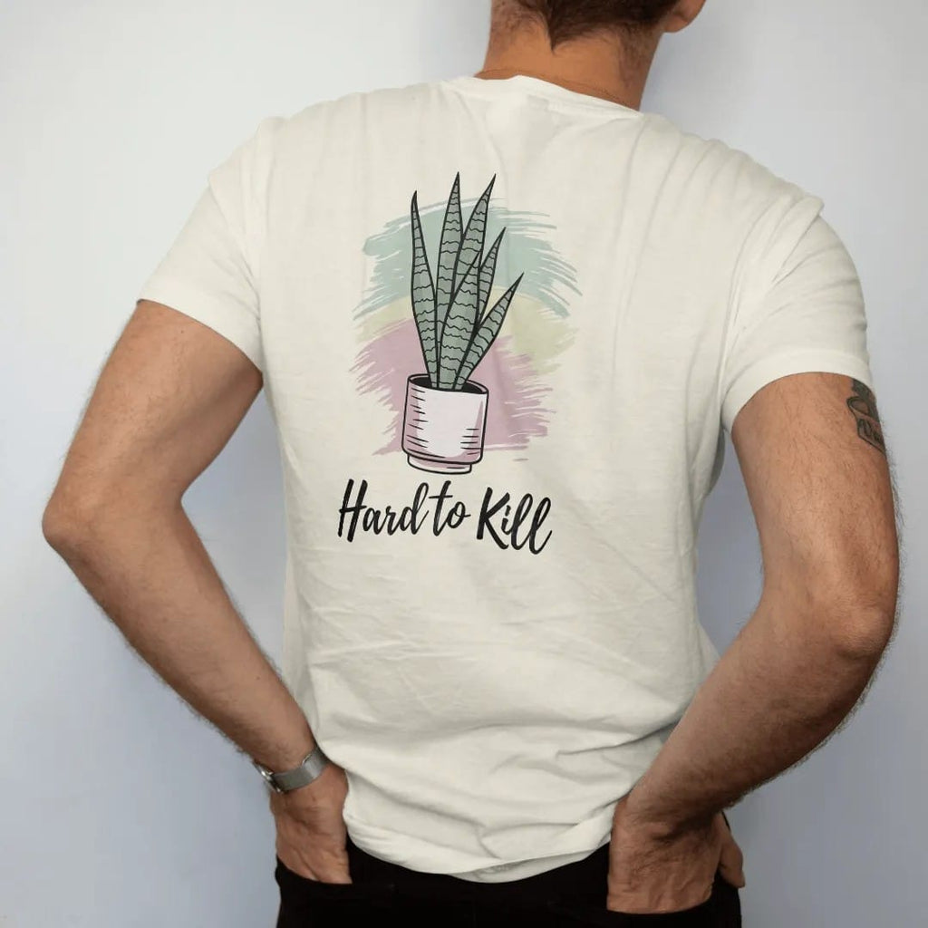 Man wearing a Ivory tee, seen from the back: a tall snake plant with upright striped leaves in a simple pot, loose brush script "HARD TO KILL" beneath, painted in loose watercolor and ink with soft mint, clay pink, cream and lime washes.