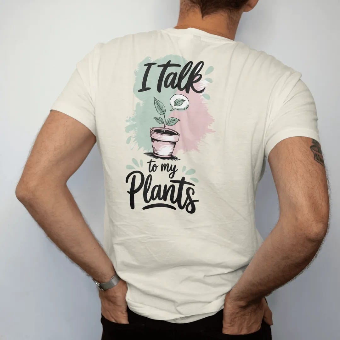 Man wearing a Ivory tee, seen from the back: a small potted plant with a tiny speech bubble holding a single leaf, "I TALK" in loose brush script above and "TO MY PLANTS" below, painted in loose watercolor and ink with soft mint, clay pink, cream…